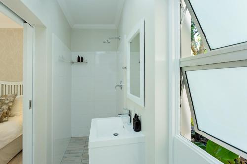 乔治Tehillah Guest House的白色的浴室设有水槽和镜子