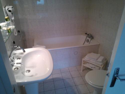 蒙特尔梅Logis Le Franco Belge的一间带水槽、浴缸和卫生间的浴室