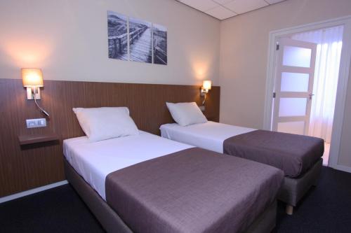 埃尔瑟尔德本格尔酒店餐厅的酒店客房设有两张床和窗户。