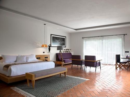 迪坡斯特兰费尔南达之家精品酒店的卧室配有一张床和一张桌子及椅子