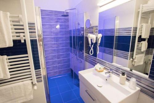 那不勒斯Casa Teresa Bed & Breakfast的浴室设有水槽和蓝色瓷砖淋浴。