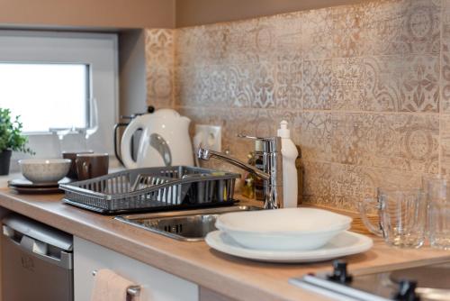 KocēniBestes apartamenti的厨房柜台设有碗碟干燥架和水槽