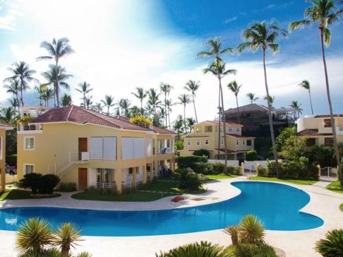 蓬塔卡纳Villas Tropical Los Corales Beach & Spa的一座别墅,设有游泳池和棕榈树
