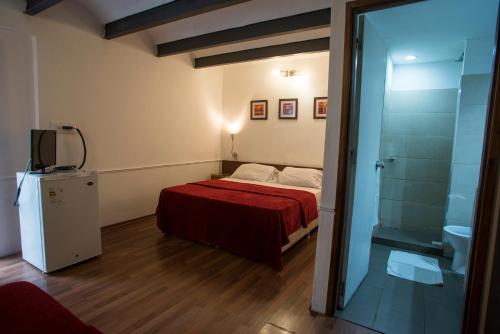 蒙得维的亚蒙得维的亚卡萨布兰卡酒店的一间小卧室,配有一张床和电视