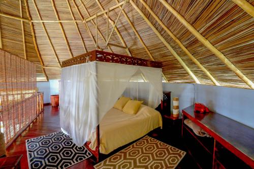 博卡斯德尔托罗蓬塔卡拉科尔阿夸旅舍的一间卧室,卧室内配有一张天蓬床