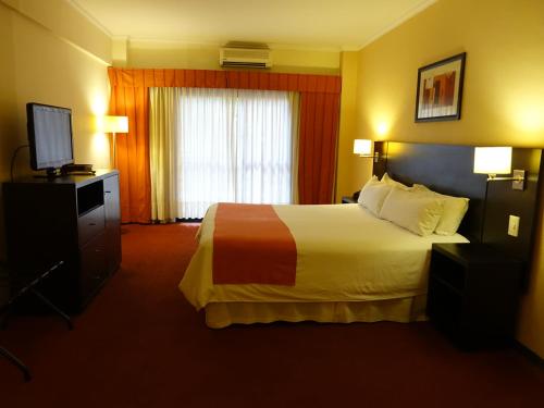 布宜诺斯艾利斯Duomi Hotel Buenos Aires的酒店客房,配有床和电视