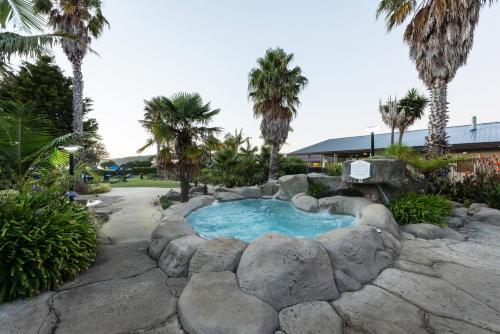 派西亚国敦大酒店&度假村 - 岛屿湾的游泳池四周环绕着岩石墙