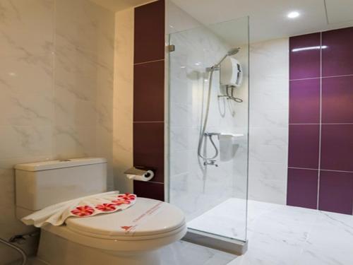 合艾合艾品客格兰酒店的一间带卫生间和玻璃淋浴间的浴室