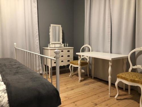 斯克伦达Skrunda Apartments Elandrum的一间卧室配有一张床、一张桌子和一台电视。