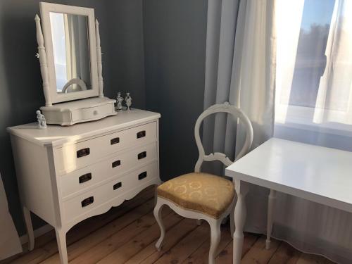 斯克伦达Skrunda Apartments Elandrum的白色梳妆台,配有镜子和椅子