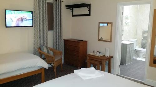 拉夫堡瑞普石制宾馆的一间卧室配有一张床、梳妆台和一间浴室