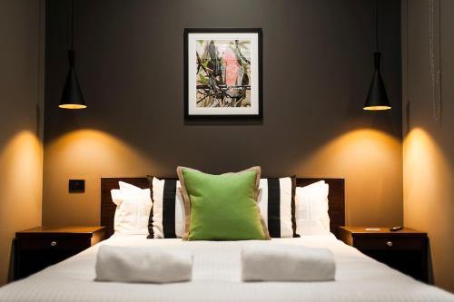 瑟尔Criterion Hotel Sale的一间卧室配有一张带绿色枕头的床