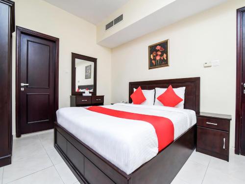 阿吉曼Paradise Inn 1 Tabasum Group的一间卧室配有一张带红色枕头的大床