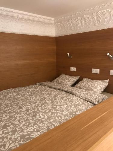 布达佩斯班伦斯格林杜尔7号公寓式酒店的一间卧室配有一张带木制床头板的床