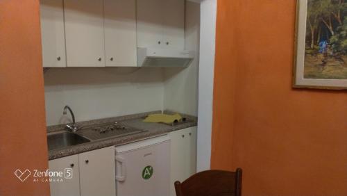 里奥马里纳Appartamento Giallo的厨房配有白色橱柜和水槽