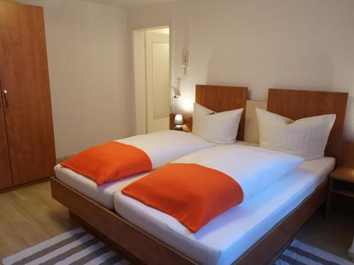 奥伯豪森Altstadt的一间卧室配有两张带橙色和白色床单的床