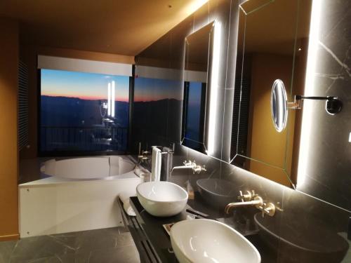 圣马力诺圣马力诺大酒店 的一间带两个盥洗盆的浴室和一个大窗户