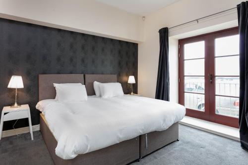艾尔Granary Suite No3 - Donnini Apartments的一间卧室设有一张大床和一个大窗户