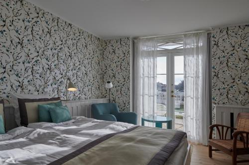 布洛克胡斯Strandhotellet的一间卧室配有床、椅子和窗户