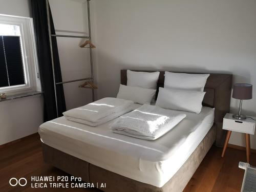 梅舍德Luxuriöse Ferienwohnung im Herzen des Sauerlandes的一张带白色床单和枕头的床