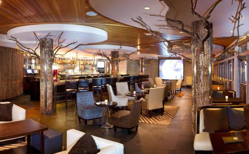 西雅图厄齐沃特贵族山庄酒店的一间带桌椅的餐厅和一间酒吧