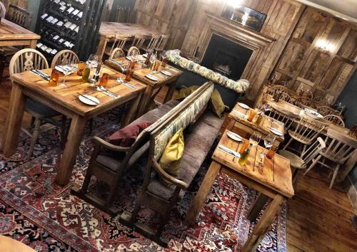 安伯利Black Horse的餐厅设有木桌、椅子和壁炉