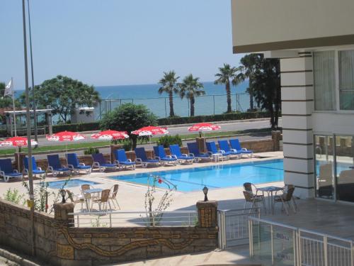 安塔利亚奥尔比亚公寓酒店的一个带椅子和遮阳伞的游泳池