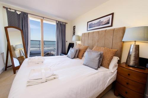 斯卡伯勒金沙酒店的卧室设有一张大白色床,享有海景