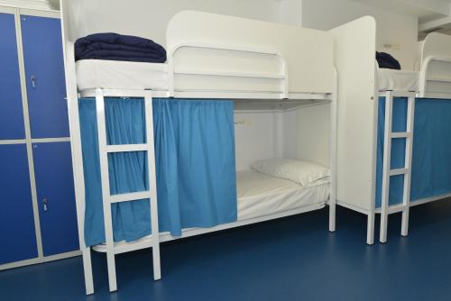 巴约讷Hostel Albergue Baionamar的一间设有三张双层床和蓝色墙壁的客房