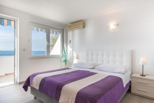 珀德垂那Apartments Zanic on The Beach的白色的卧室设有一张大床和一个窗户
