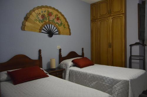 兰哈龙Casa Los Barranquillos的酒店客房设有两张床和墙上的时钟。