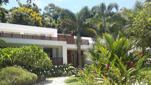 帕拉蒂Tropical Contemporary Suites的被树木和植物包围的白色房子