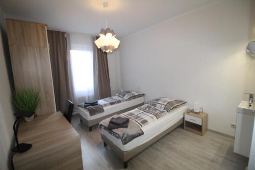 美因茨Aussicht Mainz-City - 4 Zimmer-max 7 Personen的一间卧室配有两张床和吊灯。