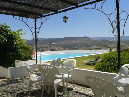 普里埃格·德·科尔多巴Villa Turística de Priego的一个带桌椅的庭院和一个游泳池