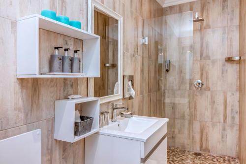约翰内斯堡Sitatunga Guest Lodge的浴室配有白色水槽和淋浴。