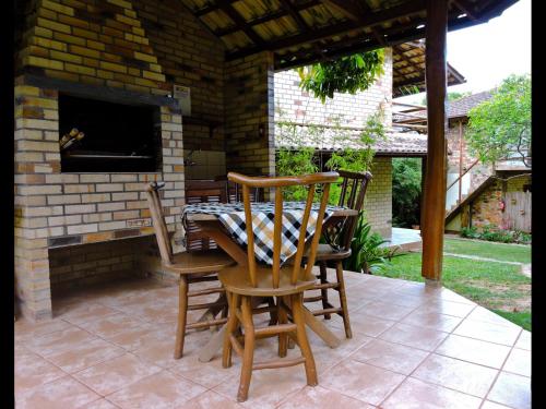 瓜尔达恩巴Pousada Morada Flor da Terra的庭院设有两把椅子和一张带壁炉的桌子。