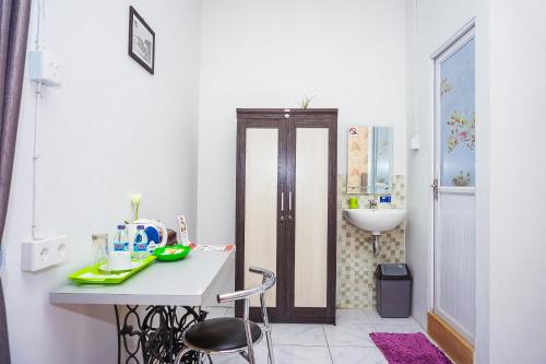 巴东OYO 433 Nelvi Guest House Syariah的白色的浴室设有水槽和桌椅