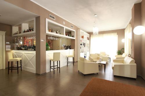 蒙特罗索阿尔马雷玛格丽特酒店的客房设有带白色椅子和桌子的酒吧。