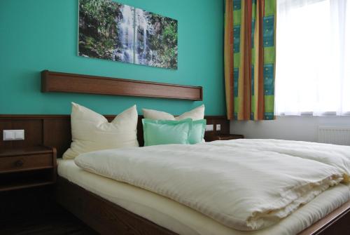 阿姆施泰滕福鲁克斯佩帕拉迪斯伽尔特酒店的卧室配有白色大床和蓝色的墙壁