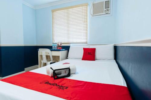 宿务RedDoorz @ Bonifacio St Cebu的卧室配有一张带红色毯子的白色床
