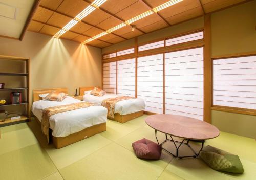 岐阜岐阜酒店的一间设有两张床和一张桌子的房间