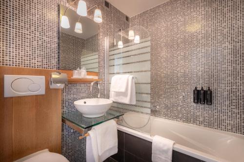 根特卡尔顿酒店的浴室配有盥洗盆、卫生间和浴缸。