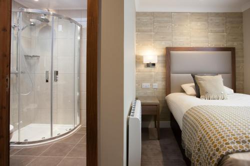 威廉堡克鲁亚川酒店的一间卧室设有淋浴、一张床和一个浴缸。