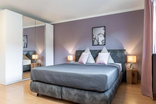 弗莱堡Wohnen auf Zeit - Innenstadt-Appartements的一间卧室设有一张紫色墙壁的大床