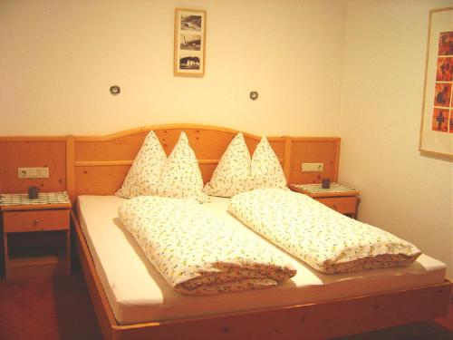 施图拜河谷新施蒂夫特Haus Harbauer的卧室内的一张带两个枕头的床