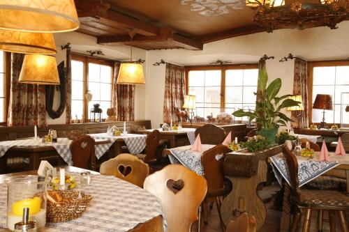 米滕瓦尔德爱普玫瑰酒店的用餐室设有桌椅和窗户。