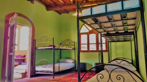 廷吉尔Dounia Hostel的客房设有两张双层床和镜子