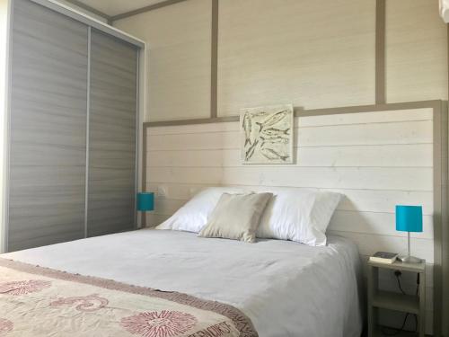 博尼法乔Les Suites De Pertamina的一间卧室配有一张带白色床单和蓝色灯的大床。