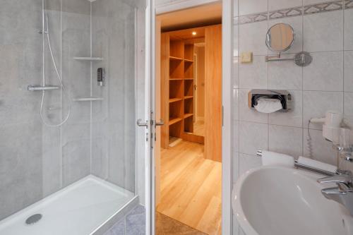 库克斯港瓦滕济科酒店的带淋浴和白色浴缸的浴室