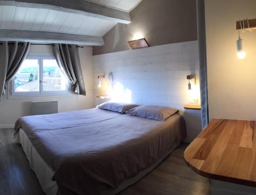 于泽斯LOGIS HOTEL RESTAURANT L' Auberge d'Uzes的一间卧室设有一张大床和一个窗户。